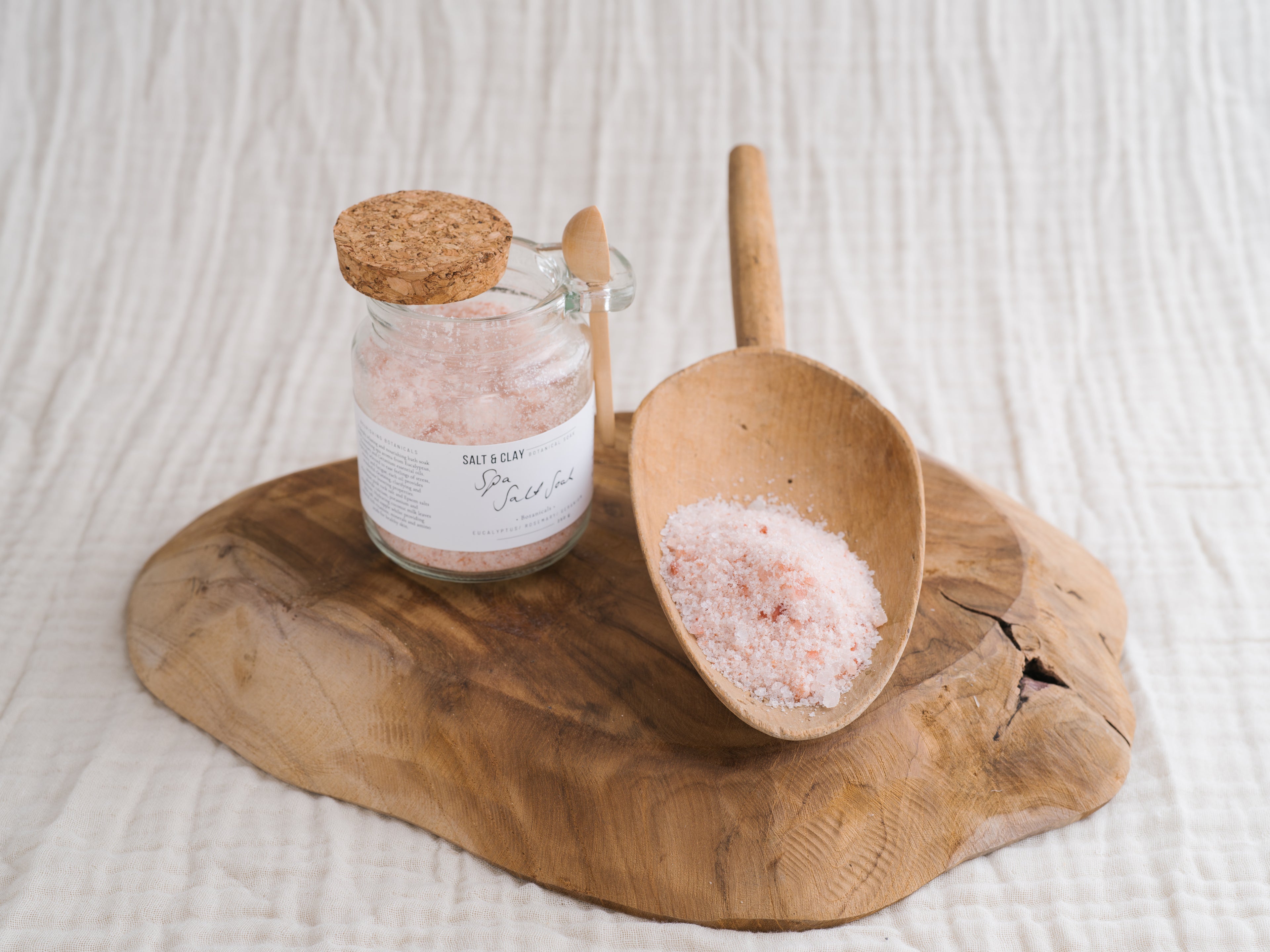 Bath salts in a jar with a wooden spoon.