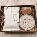 Gift set with soap in handmade white paper packaging. Ceramic soap dish with a scalloped edge.