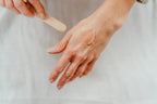 Image showing a scoop of our Brighten and Revive cleanser spread on a hand to show the creamy balm consistency. 